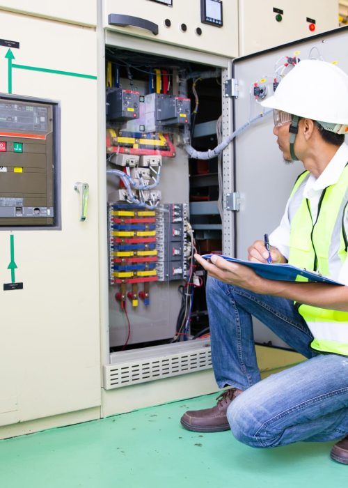 Maintenance engineers inspect relay protection system. Bay control unit. Medium voltage switchgear