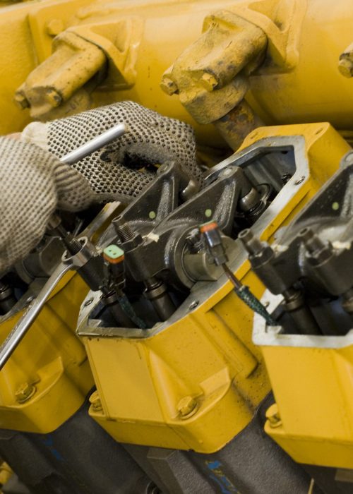 A technician performing periodic engine maintenance in a landfill gas recovery plant